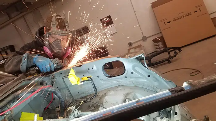 An auto technician working on a car's aluminum repair.