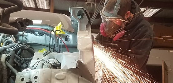 An auto technician working on a car's aluminum repair.